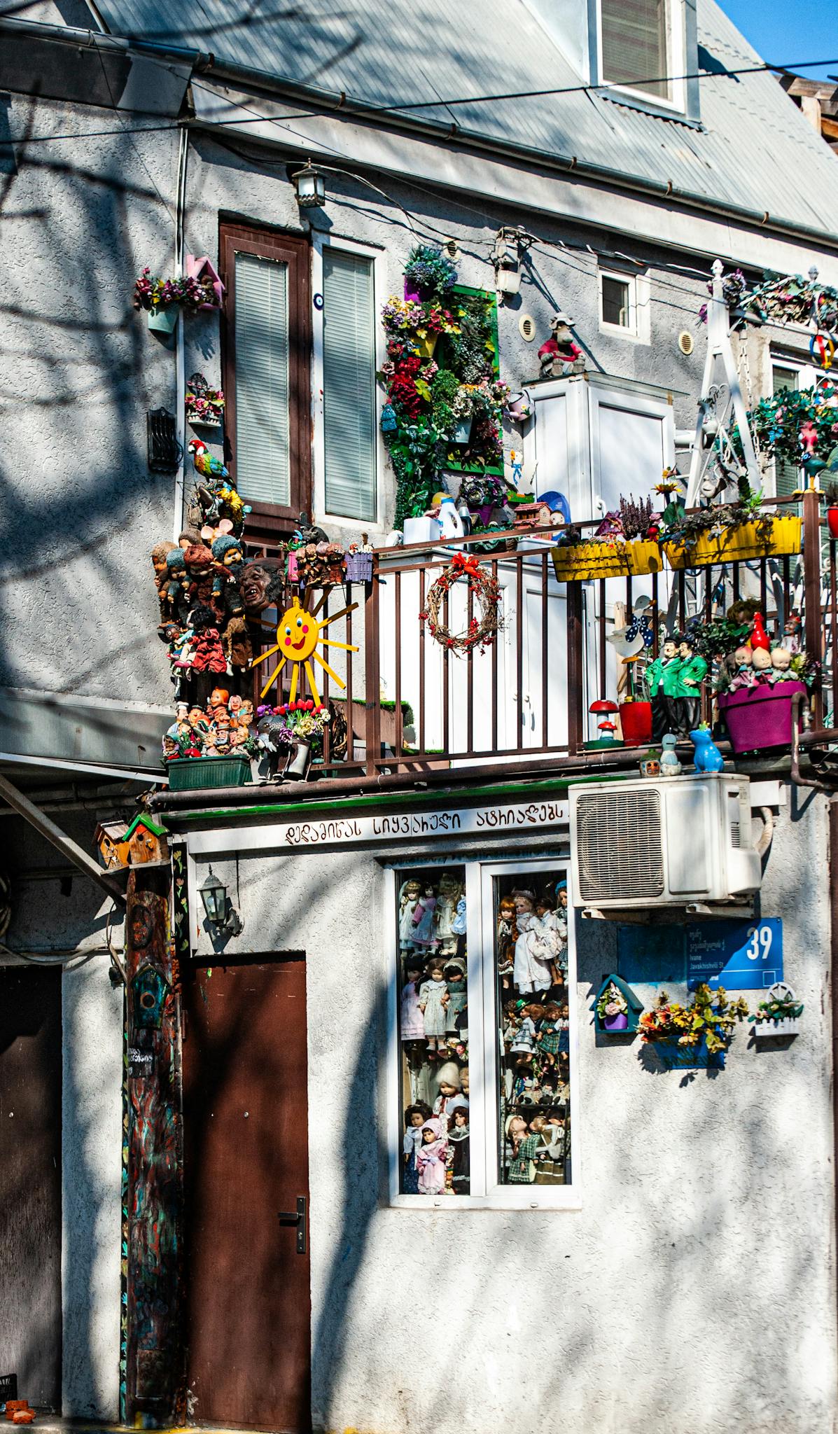A vibrant balcony adorned with colorful decorations and plants on a sunny day.